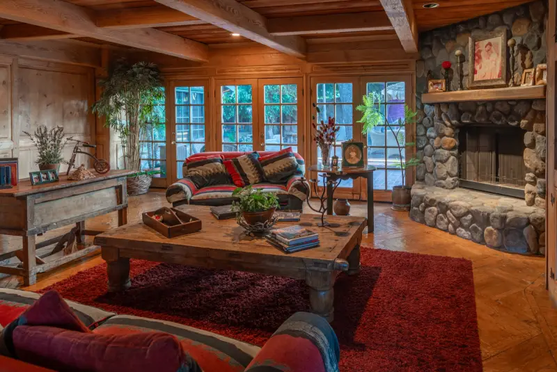 The Great Room with its stone fireplace and French windows at The Enchanted Manor