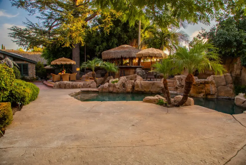 The grotto pool with its thatched palapas and gazebo bar at The Enchanted Manor