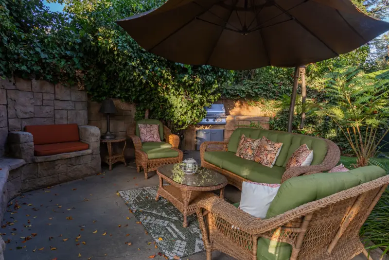 The private patio with its outdoor fireplace and wicker sofas at The Enchanted Manor